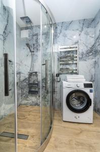 eine Waschmaschine im Bad mit Dusche in der Unterkunft Luxury apartment near metro station Osokorky in Kiew
