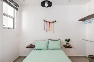 Un dormitorio con una cama verde y una ventana. en Primer Piso condo , 3 Recamaras+2.5 baños +alberca, en Cabo San Lucas 41 fotos más