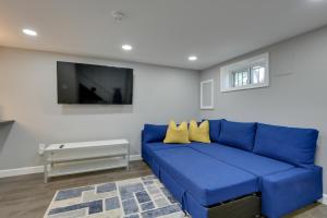 ein blaues Sofa im Wohnzimmer mit einem TV in der Unterkunft Convenient Washington, DC, Studio Near Metro Stop! in Washington