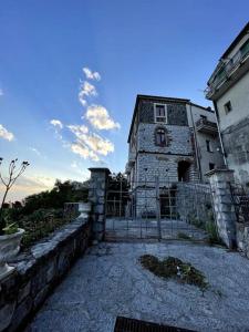ein altes Steingebäude neben einem Gebäude in der Unterkunft Antica dimora Don Pierino-CILENTO in Roccagloriosa