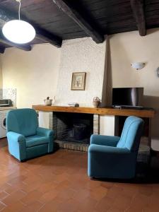 2 blaue Stühle in einem Wohnzimmer mit Kamin in der Unterkunft Antica dimora Don Pierino-CILENTO in Roccagloriosa