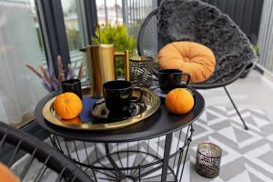 a table with a tray of oranges and cups on it at Apartamenty STUDIO in Busko-Zdrój