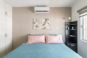 um quarto com uma cama com lençóis rosa e azul em Villa Alberca Privada 10 pax em Cabo San Lucas