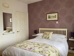 a bedroom with a large bed with a flowery bedspread at Wilmcote Bed and Breakfast in Wilmcote