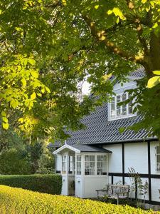 een wit huis met een bankje ervoor bij Strandby 1847 B&B in Nykøbing Falster