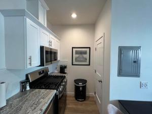 a kitchen with white cabinets and a stove top oven at Beach Apartment in Huntington Beach