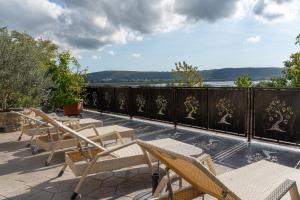 eine Terrasse mit Stühlen und Blick auf das Wasser in der Unterkunft Apartments Gea in Lucija