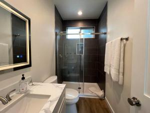 a bathroom with a shower and a sink and a toilet at Beach Apartment in Huntington Beach