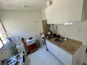 eine kleine Küche mit einer Spüle und einem Herd in der Unterkunft Apartamento 3/4 ótima localização in Aracaju