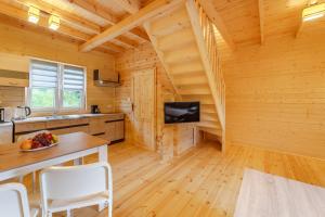 a kitchen with a table and chairs in a log cabin at Nadmorska House in Grzybowo
