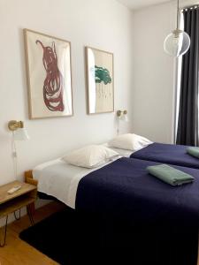 a bedroom with a bed and two pictures on the wall at Living Lounge Hostel in Lisbon