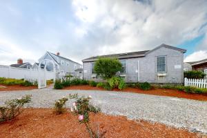 a house with a white fence and a gravel driveway at The Atlantic in Yarmouth