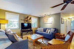 a living room with blue couches and a tv at Camp Crooked in Naples