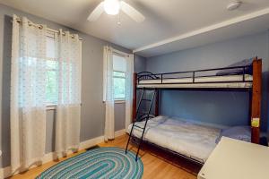 a bedroom with a bunk bed and two windows at Camp Crooked in Naples