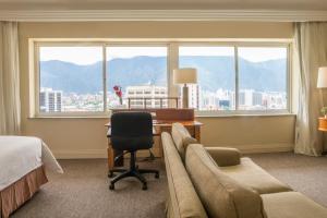 カラカスにあるHotel Tamanaco Caracasのデスク、椅子、ベッドが備わる客室です。