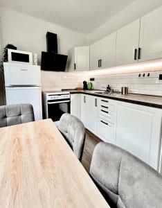 een keuken met witte kasten en een tafel en stoelen bij Apartment Lilly in Špindlerův Mlýn