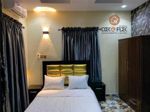 1 dormitorio con 1 cama grande con almohadas blancas en Dex & Flex Apartments 2 en Ibadán