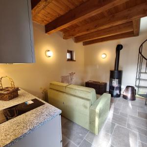 sala de estar con sofá y fogones en Baita Dinh - Villaggio dei Crodini en Crodo