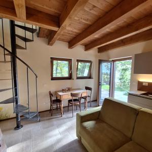 ein Wohnzimmer mit einem Sofa und einem Tisch in der Unterkunft Baita Dinh - Villaggio dei Crodini in Crodo