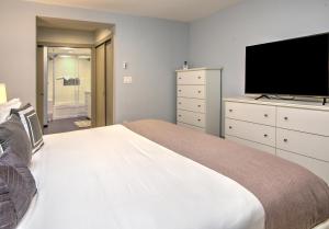 a bedroom with a large bed and a flat screen tv at Fall Ridge in Vail