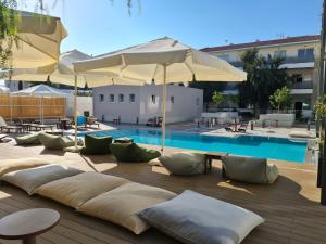 a pool with a bunch of pillows and an umbrella at Apartment Helena in Paralimni
