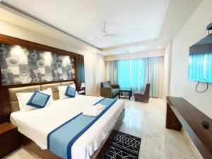 1 dormitorio con 1 cama grande y sala de estar en Hotel AMBIKA PALACE PURI en Puri