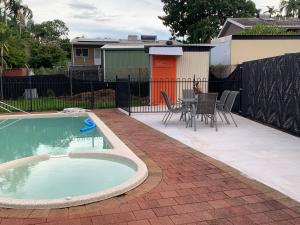 a patio with a pool and a table and chairs at Boutique Granny Flat in Paraparap