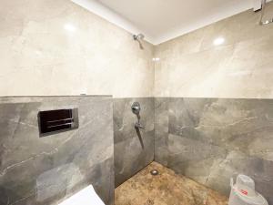 a shower in a bathroom with a tile wall at Hotel AMBIKA PALACE PURI in Puri