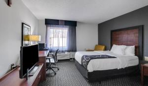 a hotel room with a bed and a desk with a computer at La Quinta by Wyndham N Little Rock - McCain Mall in Little Rock