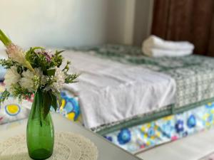 a green vase filled with flowers sitting on a table at MasTonKel in Aswan