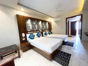 um quarto com 2 camas e almofadas azuis em Hotel AMBIKA PALACE PURI em Puri