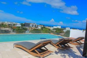 a swimming pool with lounge chairs next to a swimming pool at Luxury apartament 1 block to 5Th Avenue in Playa del Carmen