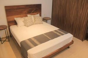 1 dormitorio con 1 cama grande y 2 taburetes en Luxury apartament 1 block to 5Th Avenue, en Playa del Carmen