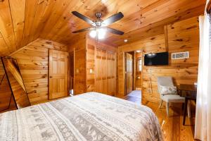 a bedroom with a bed and a ceiling fan at River's Creekside Cabin in Ellijay +35 photos