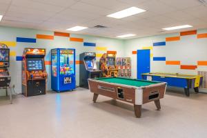 a room with arcade games and a pool table at River's Creekside Cabin in Ellijay