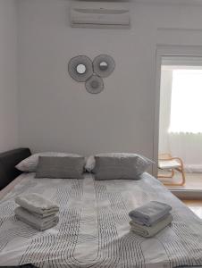 a bedroom with a bed with three pillows on it at Studio apartman Luce self CHECK IN in Osijek
