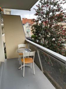 een tafel en stoel op een balkon met een boom bij Le Joan Miro - 100m des thermes in Vichy