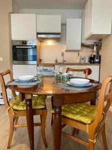 een keuken met een houten tafel met gele stoelen bij Le Joan Miro - 100m des thermes in Vichy