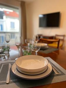 een tafel met borden en wijnglazen erop bij Le Joan Miro - 100m des thermes in Vichy