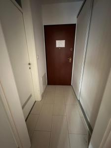 a hallway with a door and a tile floor at Studio apartman Luce self CHECK IN in Osijek