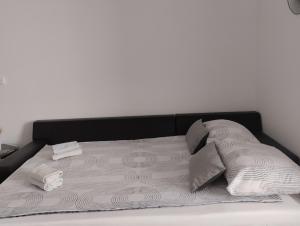 a bed with white sheets and pillows on it at Studio apartman Luce self CHECK IN in Osijek