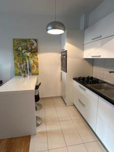 a white kitchen with a sink and a stove at Studio apartman Luce self CHECK IN in Osijek +11 photos