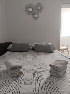 a bedroom with a large bed with pillows on it at Studio apartman Luce self CHECK IN in Osijek