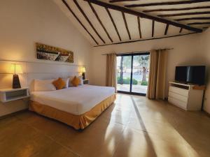 1 dormitorio con 1 cama y TV en una habitación en Sunsol Punta Blanca en San Pedro de Coche