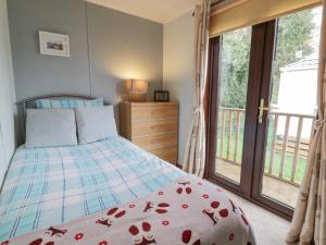 um quarto com uma cama e uma grande janela em Roe Deer Lodge em Newton Stewart