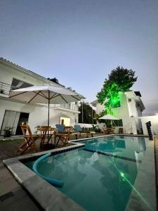 uma piscina com uma mesa e um guarda-sol em Casa céu de estrelas em Arraial d'Ajuda