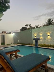 ein Swimmingpool mit Tisch und Bänken vor einem Gebäude in der Unterkunft Casa céu de estrelas in Arraial d'Ajuda + 15 Fotos