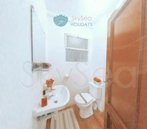 a bathroom with a white toilet and a sink at SkySea Holidays MALAGA BAILEN in Málaga