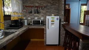 a white refrigerator in a kitchen with a counter at MIRAVALLES RANCHO - Rio Celeste Dreams in Bijagua