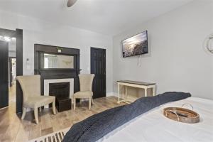 a bedroom with a bed with a fireplace and chairs at Workfriendly home with priv yard, near downtown in Jeffersonville